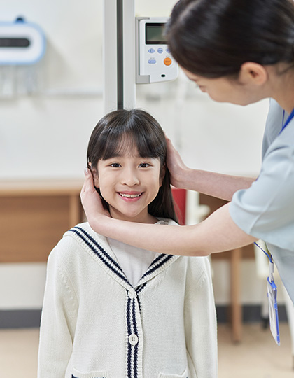 의료진이 아이의 머리 옆을 살피는 사진
