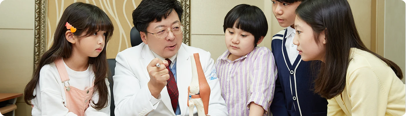 진료실에서 의료진과 아이들·보호자가 함께 있는 사진