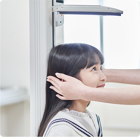 신장계 앞에서 키를 재는 여자아이 사진
